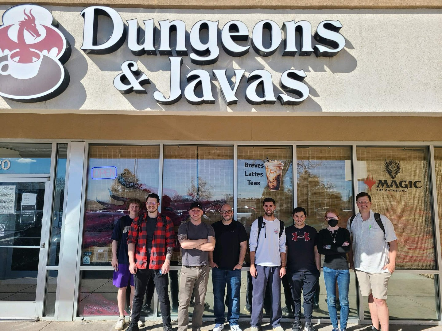 Group of people standing in front of a 'Dungeons & Javas' store